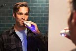 Man using dual head toothbrush