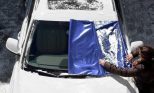 winter-windshield-cover being removed from car windshield